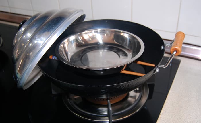 A Chinese wok , a pair of wooden or bamboo chopsticks and a dome-shaped cover - an all-time favorite for those in need of a steamer in a hurry.