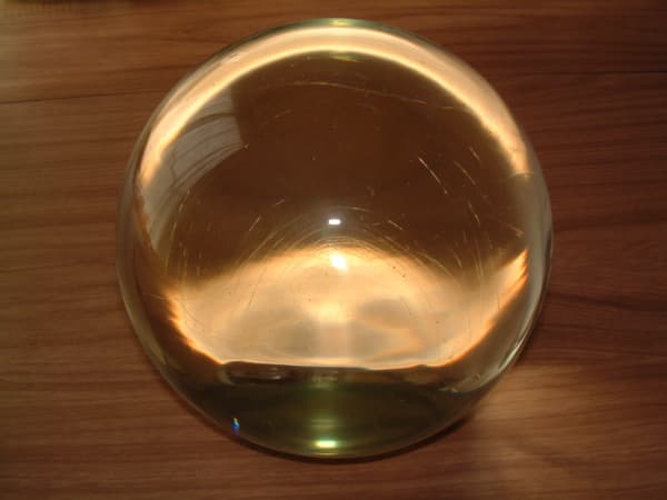 See those thin lines inside the ball that showed up from the camera flash? That's one key sign a crystal ball is glass and not quartz. Another sign is tiny bubbles.