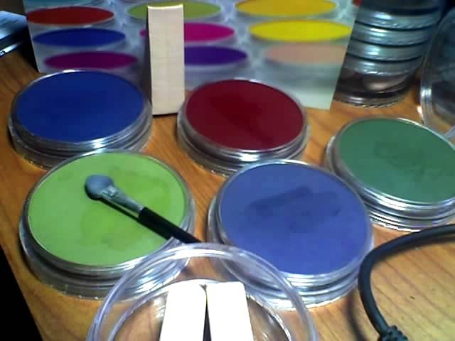 Five Extra Dark Shades Pan Pastels open for use with tools. The wedge sponge standing on end behind them came in the tool jar under the stack along with two Sofft knife covers and the mini applicator.
