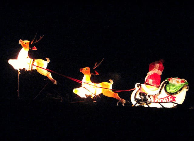 Rudolph leading Santa's sleigh in the night sky