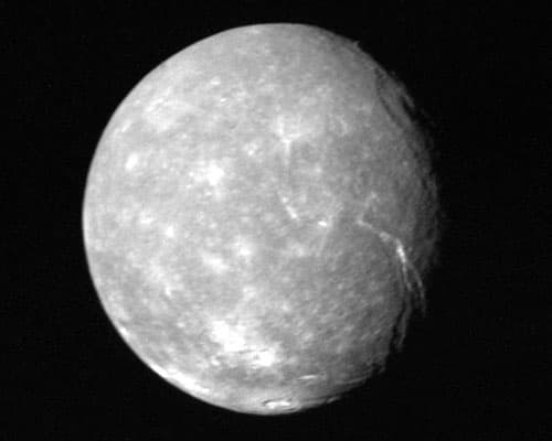 The surface of Uranus's largest moon, Titania, features trough valleys, indicative of geological activity.