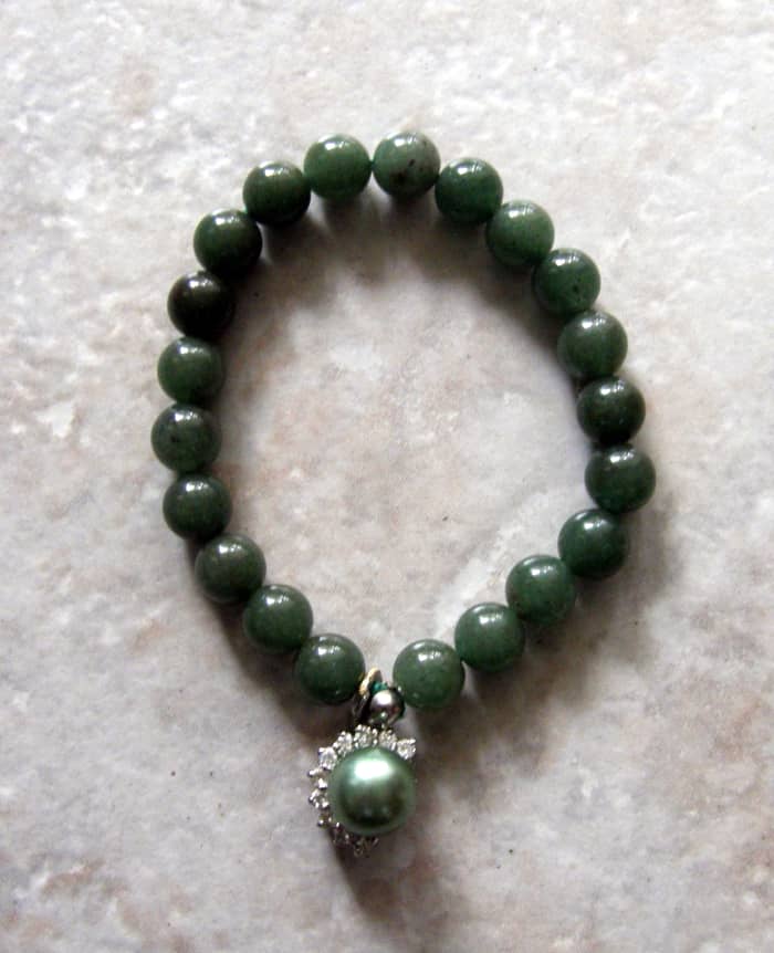 Jade bracelet with enhanced green pearl, surrounded by cubic zirconias. Many cultures, including the Irish, see the color green as a symbol of good luck.