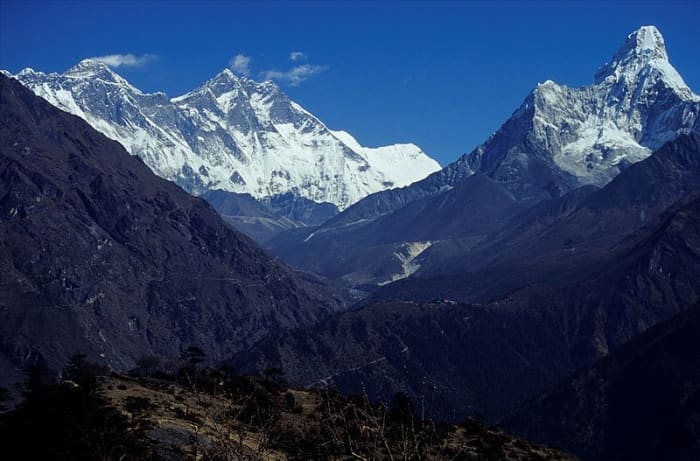 Mount Everest (in the clouds) and the peak of Ama Dablam (to the right.)