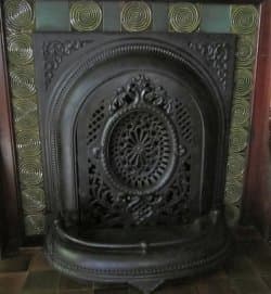 Coal burning fireplace with cast iron grille in front. © 2012-15 Restoration Fabrics & Trims LLC/Old House Interiors