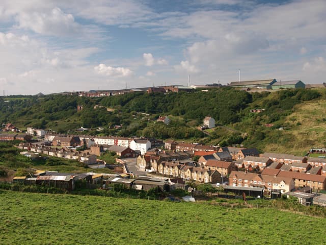 Skinningrove village seen from the old jetty trackbed, with the much rationalised, almost phased out steel works on the plateau behind