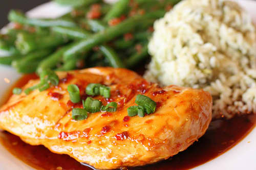 Skillet glazed marinated chicken breast garnished with scallions. Served with ginger cilantro rice and gazpacho green beans.