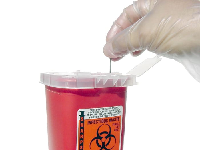 Disposing needles and samples in a sharps container is standard procedure used by scientists. As you can see, the biohazard sign is labelled on this container.