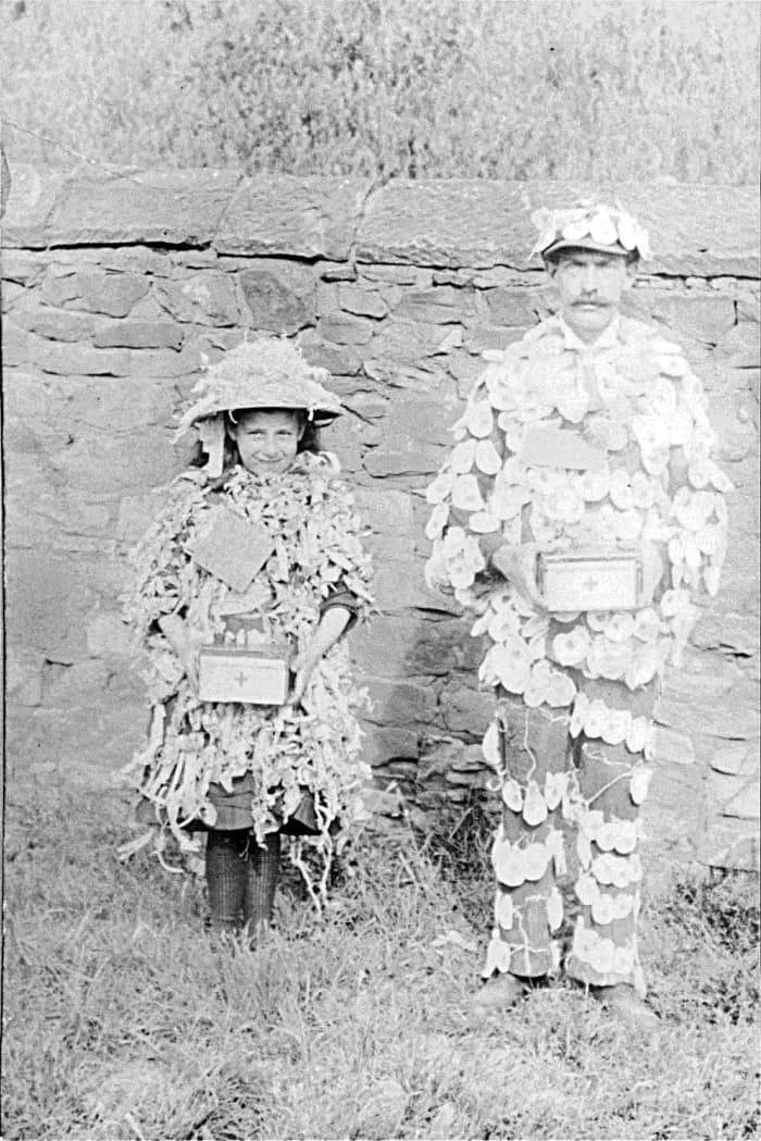 Grandad's father with daughter Annie Triggs dressed in outfits covered in poppies and their boxes have a red cross on them. They are collecting for the Red Cross to help the war effort during World War I.