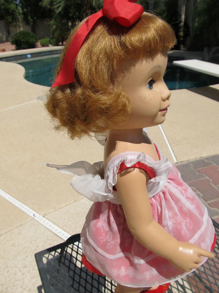 This Chatty Cathy is a world traveler she has seen a lot of history in her 57 years on this old world. She wears an original red Chatty sun suit with the ruffles on the but under an original white nylon pinafore with a matching red underskirt.