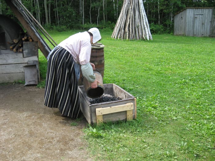 A docent reenacts the activities of an Acadian woman of the 1700s in New Brunswick, Canada.