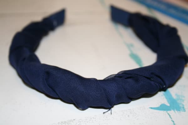 I wound up twisting it around the headband and then gluing it at each end. Then, I took my needle and thread and stitched together the materials to give it a more uniform look.