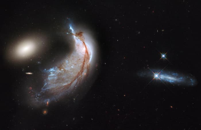 This interacting galaxy duo is collectively called Arp 142. The pair contains the disturbed, star-forming spiral galaxy NGC 2936, along with its elliptical companion, NGC 2937 at left. Once part of a flat, spiral disk, the orbits of the galaxy's star