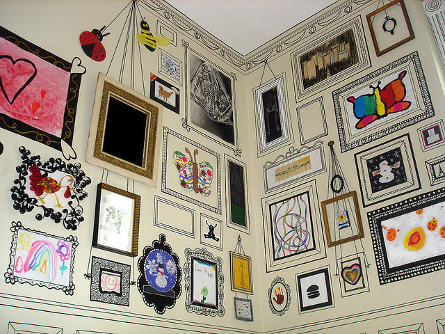This fantastic craft room wall has been created by painting photo frames on plain wallpaper. Artwork and photos are stuck inside the frames.