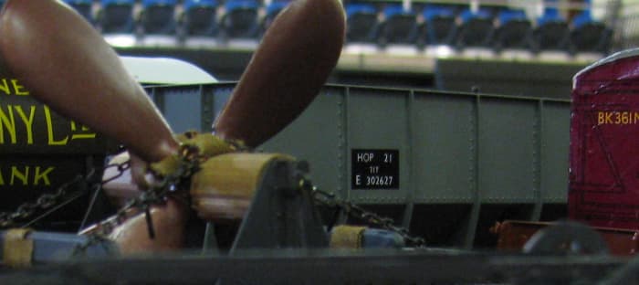 A finished 21T mineral hopper in BR TOPS livery (Total Operations Processing System, introduced 1972) seen past a ship's propeller and early BK container here in an array of vehicles