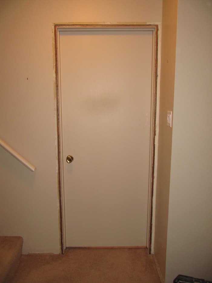 Old door waiting to be ripped out. Cut the door out by using a reciprocating saw and cutting between the jamb and the framing.