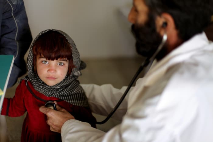 An Afghan physician listens to an Afghan girl's heart at a clinic on Camp Clark, Khowst province, Afghanistan.