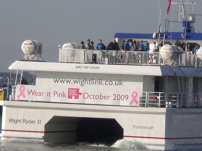 The whole world benefits from public awareness and support for breast cancer prevention, treatment, and cure. This is the stern of the Wightlinks Wight Ryder II and a poster for breast cancer awareness, October 2009
