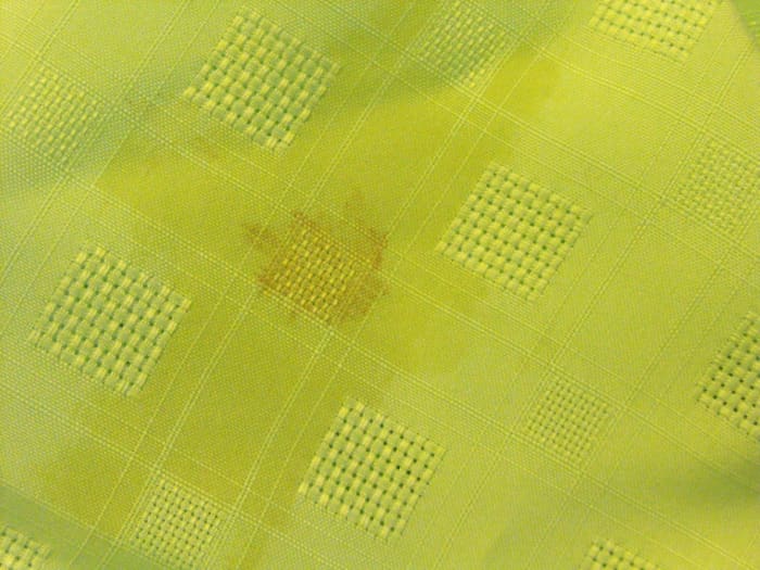 This appears to be gravy...there is a dark stain with an oily fringe in the shape of a cross!