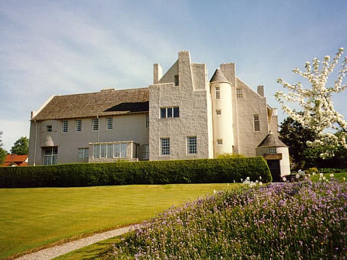 The protruding round turrets and towering chimneys of Hill House allude to the Scottish Baronial Style influence.