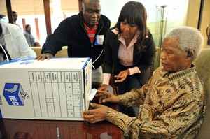 Mandela casting his vote at home assisted by his granddaughter, Ndleka Mandela, and the IEC President Officer Mr. Mshali,in his home in Houghton, Johannesburg.