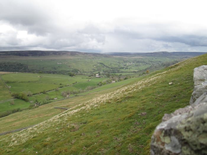 High up on the slopes of Swaledale, look back towards Reeth. A narrow road leaves the B6270 west of Reeth and climbs the daleside toward its crest where you can look south into Wensleydale.