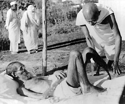 Mahatma Gandhi giving massage, 15 min. daily, to a leper patient, the Sanskrit scholar Parchure Shastri, at Sevagram Ashram, 1940.