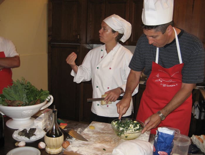 Chef Giuseppina demonstrates the "four-finger pinch" as a student prepares the ravioli filling