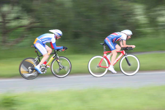 Time Trial cyclists looking aerodynamic in their Giro Advantage aero helmets. Features bikes are a Cervelo P3 Track frameset and Giant TCR Aero.