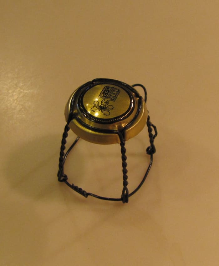 This is the wire frame from a champagne cork. With some rearranging, you can turn it into a tiny chair like one you see in an ice cream shop.