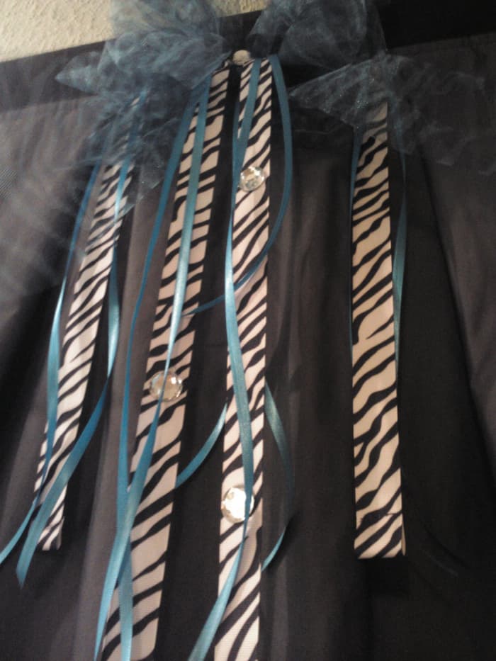 The addition of zebra ribbon, blue netting and rhinestones makes the changing room shine! A chair, rug and mirror make it functional! All in all a great alternative for outdoor events!