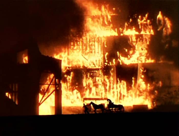 Their wagon passes close to the burning ammo, with sparks flying which could set off an explosion if it reaches the railroad cars. Rhett must wrap the horse's eyes with Scarlett's shawl to get him to pull them through this inferno!