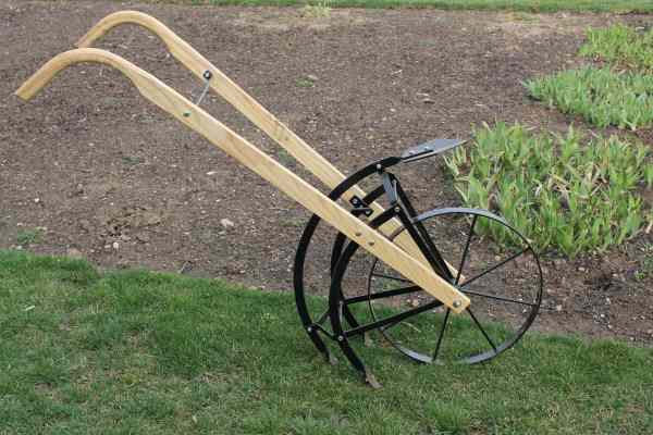Amish made flip and go cultivator. Has garden plow on one side and cultivator tangs on the other side.