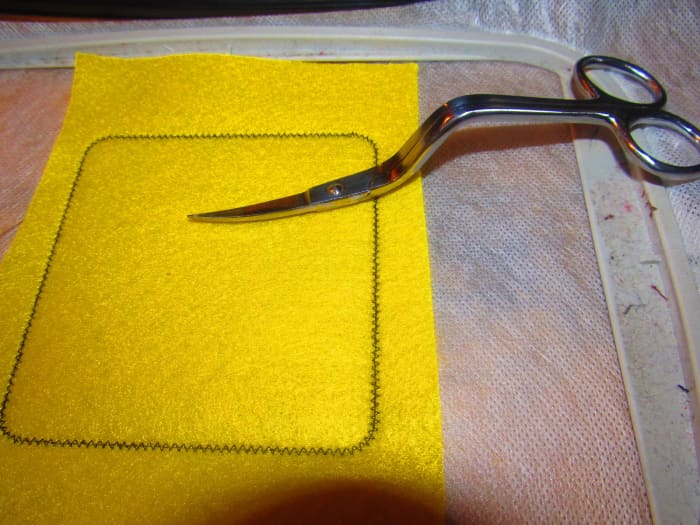 Once your fabric has been tacked down, use your sharpest scissors to trim around the patch.
