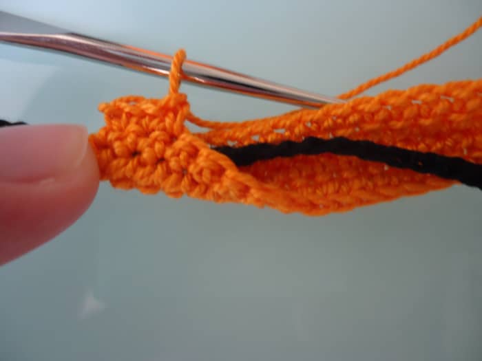 After working some sc's, you can see that the tie is effectively trapped inside the collar / waistband.