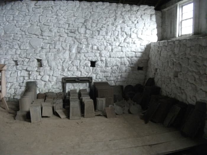 Iron stove parts stacked in the casting house of Hopewell Furnace.