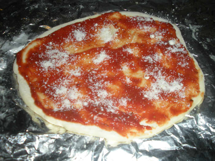 6. Bake each crust 2 minutes then put on toppings. Start with sauce and Parmesan cheese.