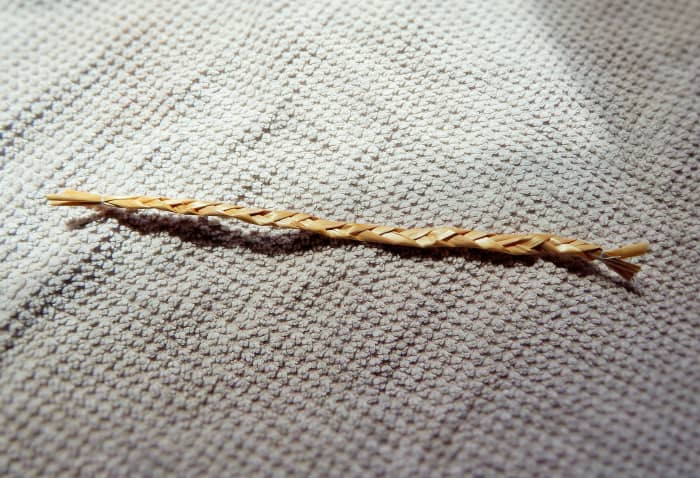 Fig. 3. Take 3 pieces of straw of equal length for the arms of your Straw Man. Plait or simply tie on each end.