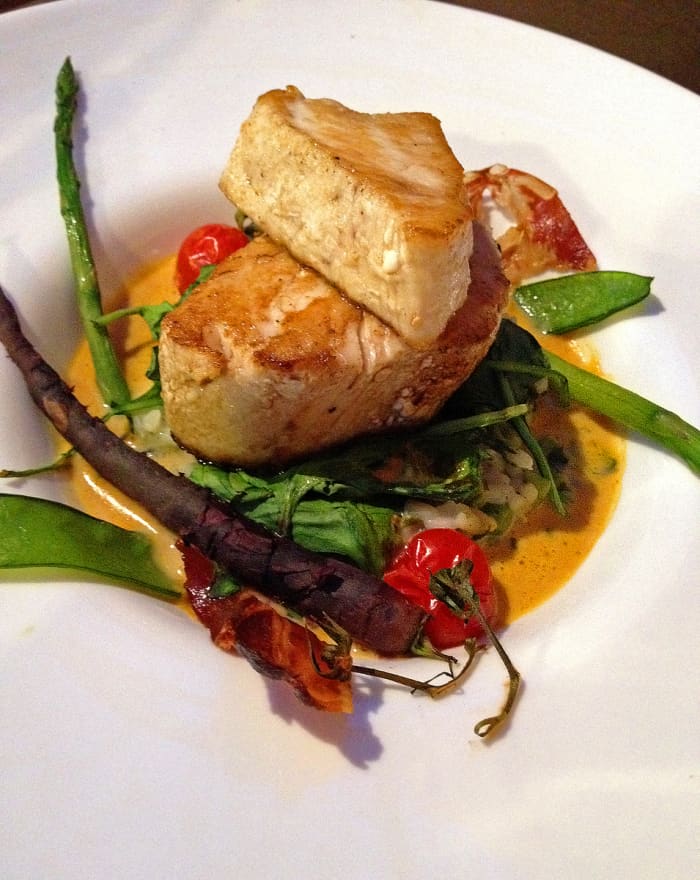 Pan seared tuna in saffron sauce, with Mediterranean rice and sauteed baby vegetables at Le Chapon Fin.