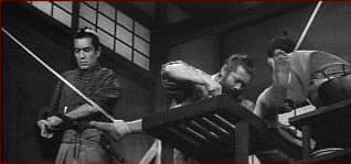 Red Beard and a colleague operate on a patient as Yasumoto struggles to keep her still on the operating bed.