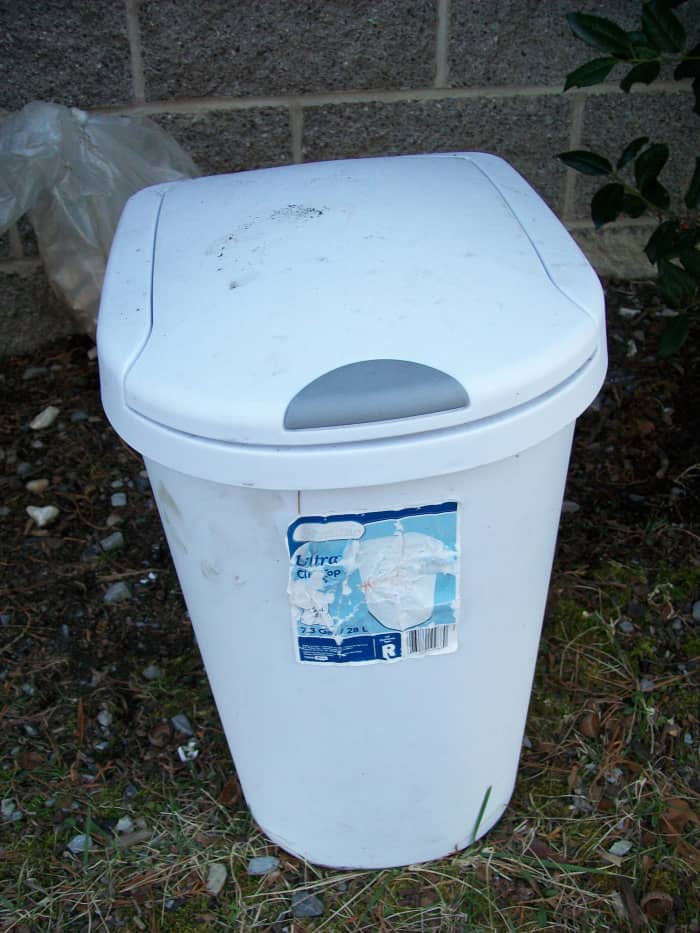 A small trash can that I use to store coffee grounds outside before using them in the garden or in plant containers
