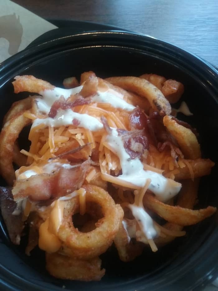 ARBY'S FAST FOOD RESTAURANT REVIEW. Food photo: Crispy and tasty curly fries with bacon, served at Arby's fast food restaurant. Arby's restaurant offers plentiful amounts of food for the price. Serving sizes are very generous.
