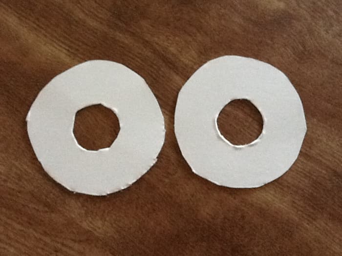 Cut out 2 circles from cardboard. Cut 2 circles from center to make a doughnut. The size of the circle will depend on how big a pom pom you want. I used a drinking glass for thew outside circle, for the inside I used a bottle cap.