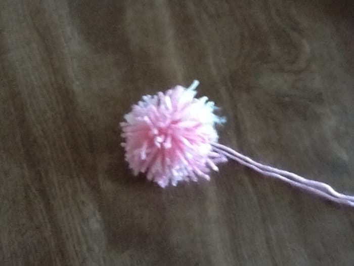 Leave the long tails , They will be used to attach the pom pom to your hat. You can give your pom pom a little trim to round it up if you like.