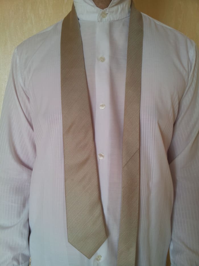 Step 1. Place the tie around your neck. Make sure that the wide end touches your belt in the middle.