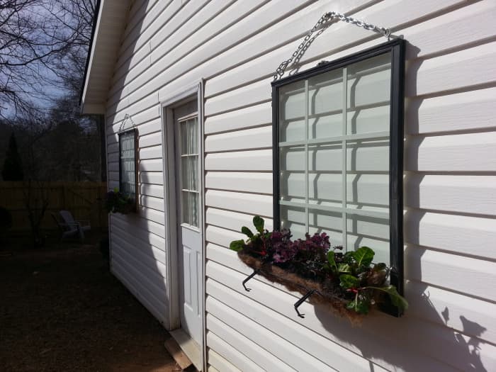 I had to turn the wrought iron planters around to hook onto the old windows. The plants will eventually grow hanging over the basket to hide the metal brackets.