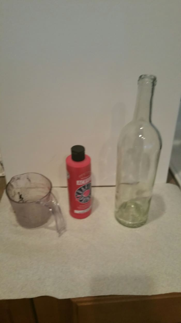 You'll need a wine bottle with the labels removed, some paint (I used acrylic), and an old measuring cup or something you can easily pour from.