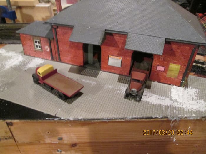 The goods shed's been secured in place, granite sets added to front. A connecting road needs to be laid in to the coal depot under the access road via a tunnel. Front 'bleeds off' the layout.