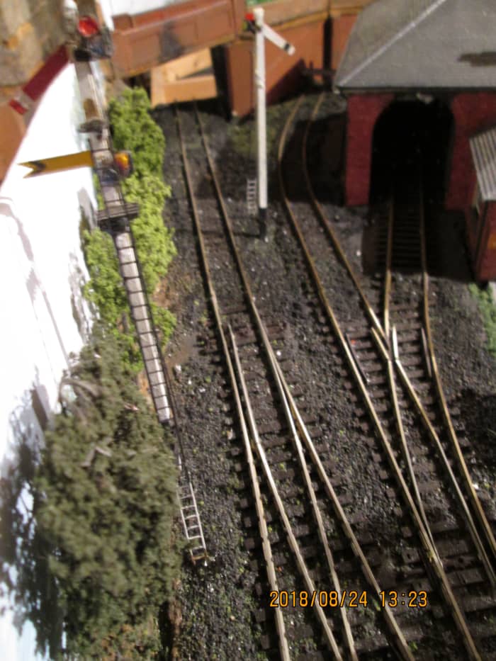 Visible over the occupation bridge parapet from the platform are the starter and fixed distant arms. As the branch is single track as far as the next station, caution is called for - spot the deliberate mistake? Both signals are 'off'!.