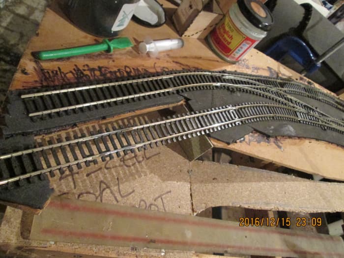 The grey underlay foam has been roughly cut to shape for the track formation, track in the coal depot suspended over the opening between buffer stop heading and main area