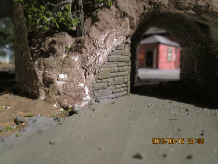 The stone-built underpass walls and road surface have been painted. All that remains is for the tunnel mouth quoin facing, scenic scatter and assorted 'vegetation' to be added in this area